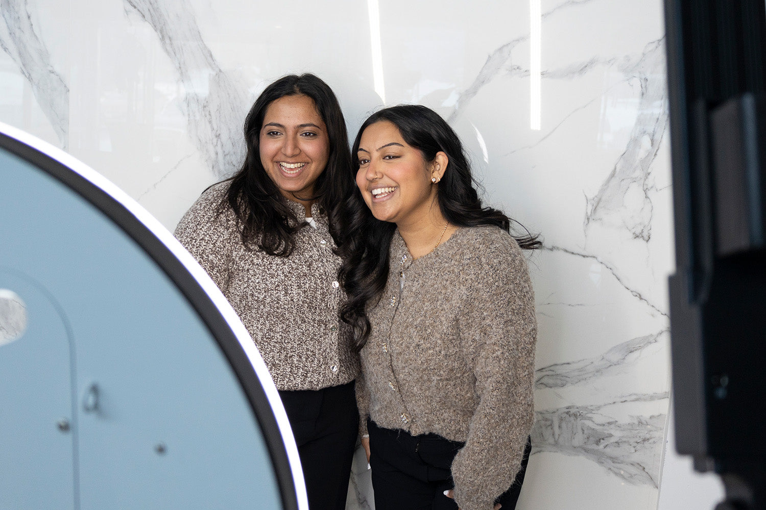 Two women smiling while standing together.